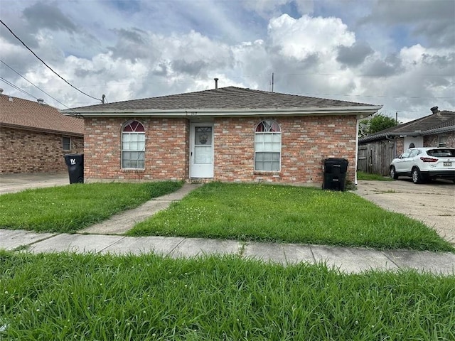 3417 Shangri La Dr, Chalmette, LA 70043 - view of front facade with a shingled roof, a front yard, and brick siding