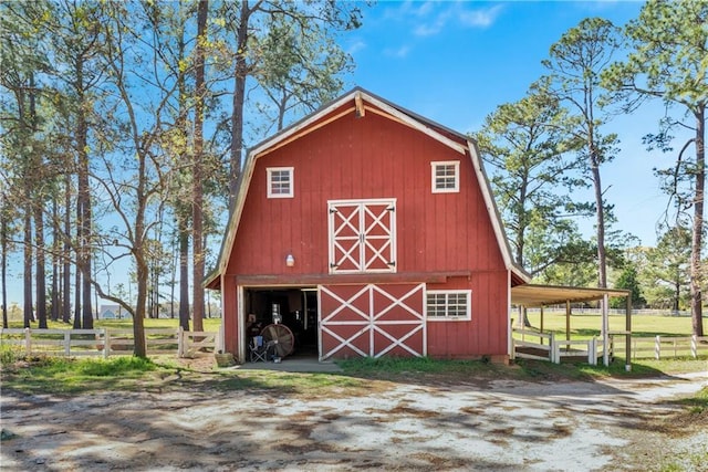 view of barn featuring fence