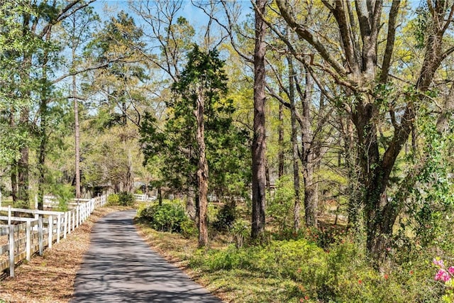view of home's community featuring fence and a wooded view