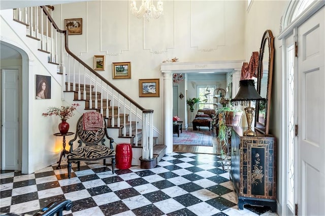 entrance foyer with stairway, arched walkways, and tile patterned floors