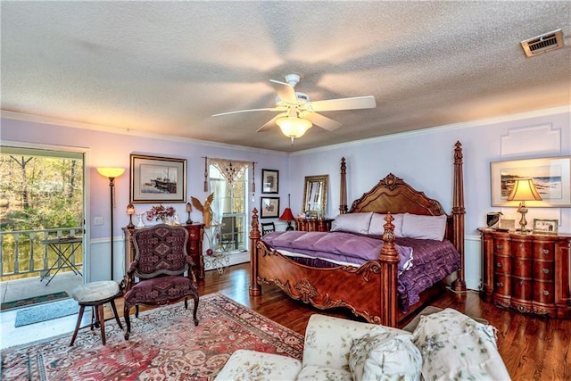 bedroom featuring access to exterior, wood finished floors, visible vents, and a textured ceiling