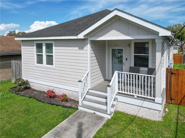 4409 Jeanne Marie Pl, New Orleans, LA 70122 - bungalow-style house featuring a front lawn, covered porch, fence, and roof with shingles