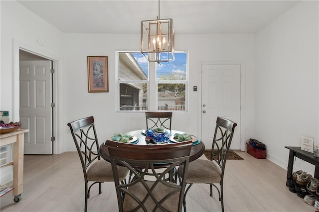 4409 Jeanne Marie Pl, New Orleans, LA 70122 - dining area featuring baseboards, light wood-style flooring, and a chandelier