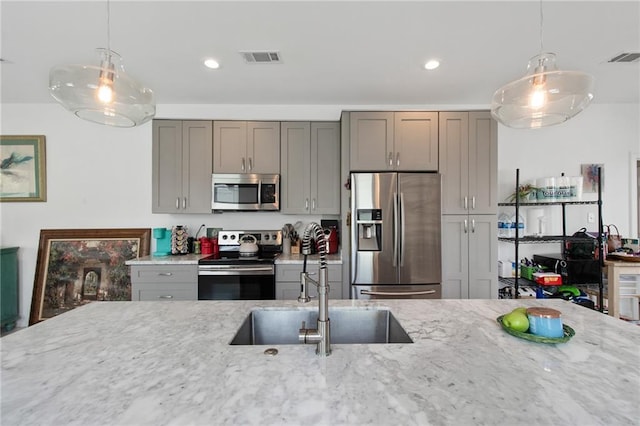 4409 Jeanne Marie Pl, New Orleans, LA 70122 - kitchen featuring visible vents, light stone countertops, stainless steel appliances, a sink, and hanging light fixtures