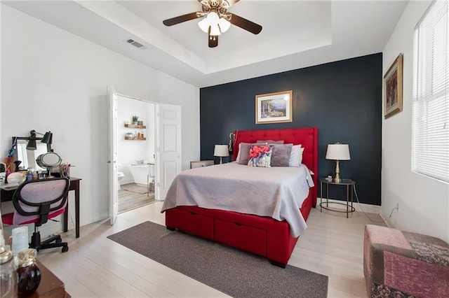 4409 Jeanne Marie Pl, New Orleans, LA 70122 - bedroom with visible vents, an accent wall, wood finished floors, and a raised ceiling