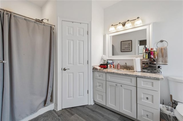4409 Jeanne Marie Pl, New Orleans, LA 70122 - full bathroom featuring toilet, a shower with shower curtain, wood finished floors, and vanity