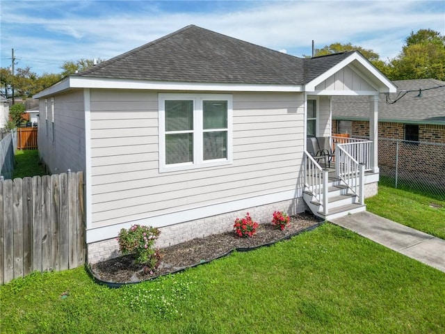 4409 Jeanne Marie Pl, New Orleans, LA 70122 - view of front of property featuring a shingled roof, fence, and a front lawn