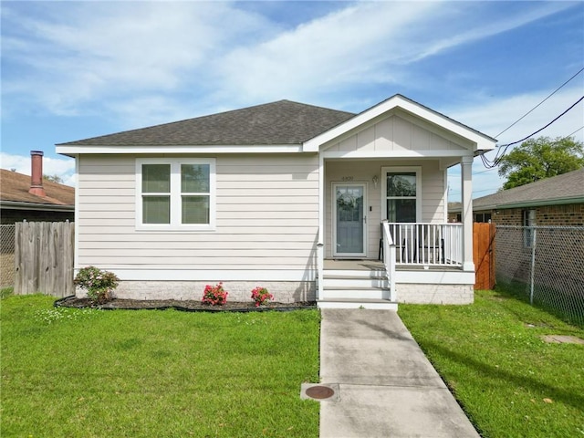 4409 Jeanne Marie Pl, New Orleans, LA 70122 - bungalow-style house featuring a shingled roof, fence, a porch, and a front yard