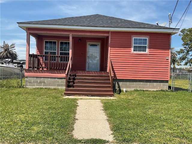 view of front of property with covered porch, a shingled roof, fence, and a front lawn