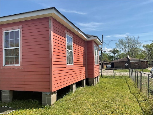 view of home's exterior with a yard and fence