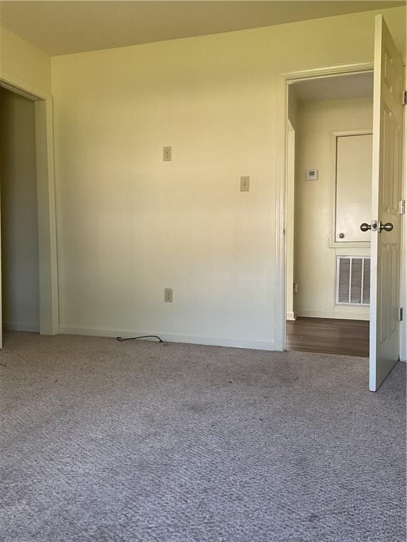 carpeted spare room featuring baseboards and visible vents