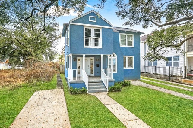 3415 Louisiana Ave Parkway, New Orleans, LA 70125 - view of front of property with a front lawn, fence, stucco siding, and a porch
