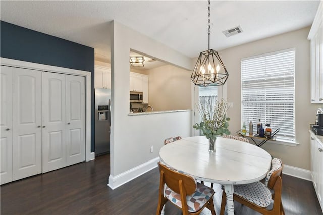 4719 Annunciation St Unit 4719, New Orleans, LA 70115 - dining area with baseboards, dark wood-style flooring, visible vents, and a chandelier