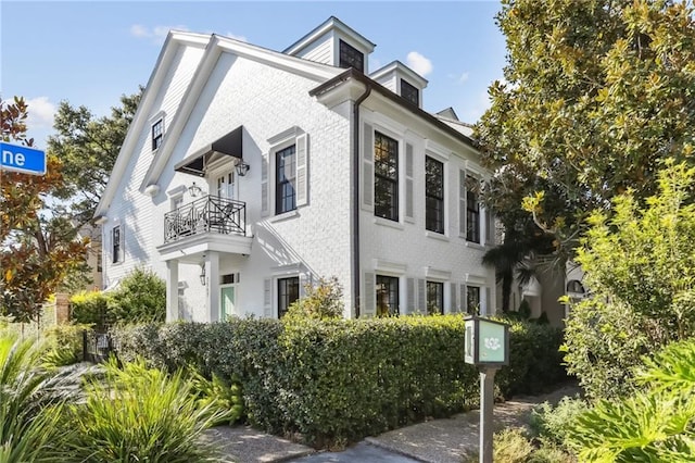 view of front of house with a balcony and brick siding