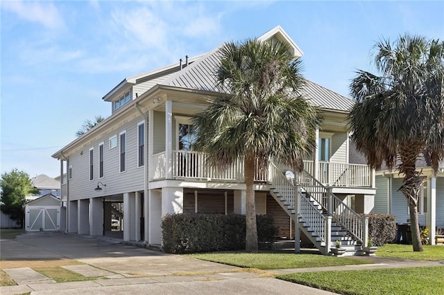 5533 Woodlawn Pl, New Orleans, LA 70124 - view of front facade featuring a carport, stairway, concrete driveway, a porch, and metal roof