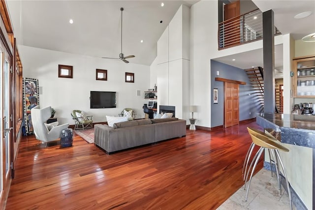 5533 Woodlawn Pl, New Orleans, LA 70124 - living area featuring stairs, ceiling fan, a high ceiling, wood finished floors, and baseboards