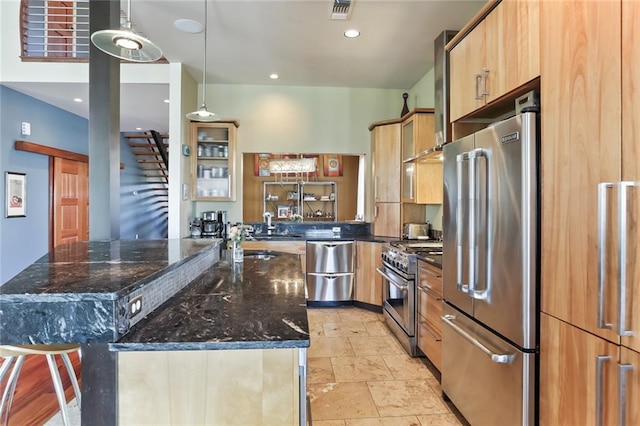 5533 Woodlawn Pl, New Orleans, LA 70124 - kitchen featuring high quality appliances, an island with sink, dark stone counters, pendant lighting, and a sink