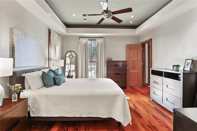 5533 Woodlawn Pl, New Orleans, LA 70124 - bedroom with wood finished floors, a tray ceiling, and ceiling fan