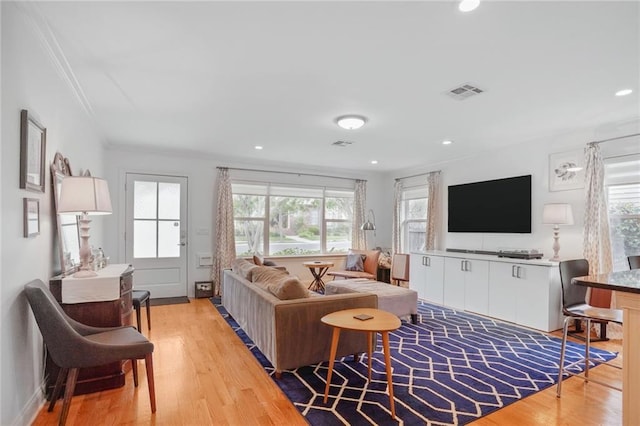 living room with wood finished floors, recessed lighting, ornamental molding, and visible vents