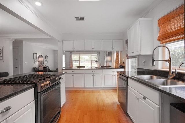 kitchen featuring crown molding, gas stove, stainless steel dishwasher, a sink, and visible vents