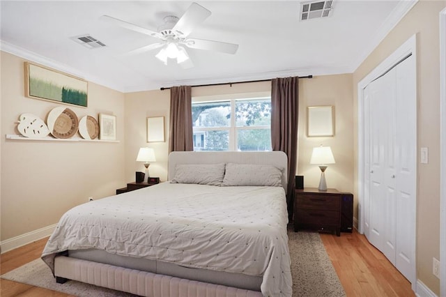 bedroom featuring light wood-type flooring, visible vents, and crown molding