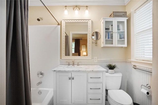full bath featuring a wainscoted wall, shower / bath combo with shower curtain, plenty of natural light, and toilet