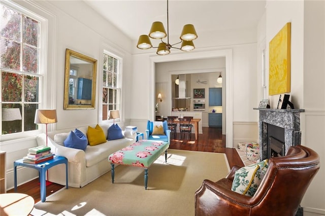 living area featuring a fireplace, wood finished floors, and a chandelier