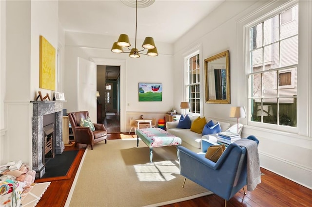 living room featuring hardwood / wood-style floors, a premium fireplace, and a chandelier