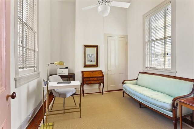 sitting room featuring baseboards, carpet flooring, and a ceiling fan