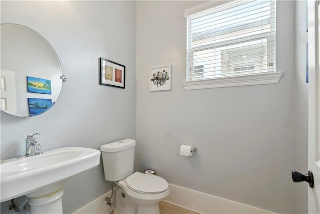 bathroom with toilet, tile patterned floors, and baseboards