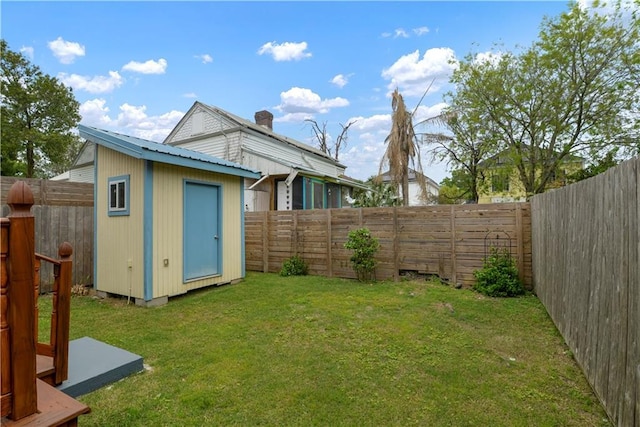 view of yard with a storage unit, a fenced backyard, and an outdoor structure