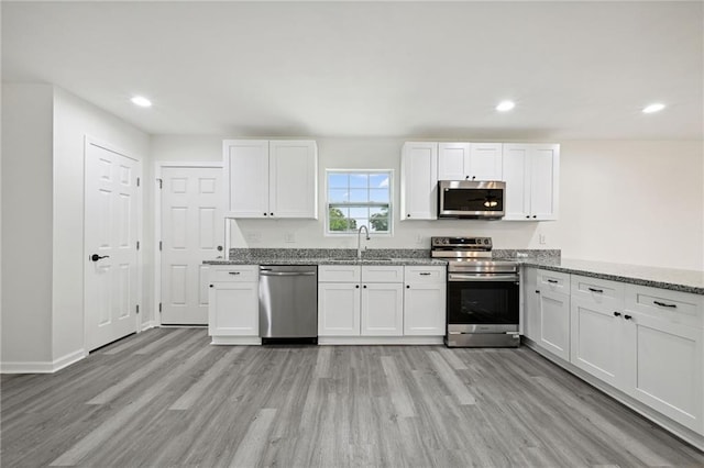 2328 Riverbend Dr, Violet, LA 70092 - kitchen featuring stainless steel appliances, light wood-type flooring, light stone counters, and recessed lighting