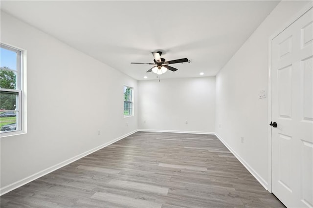 spare room featuring a ceiling fan, baseboards, recessed lighting, and wood finished floors