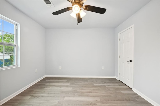 empty room with ceiling fan, baseboards, light wood-type flooring, and visible vents