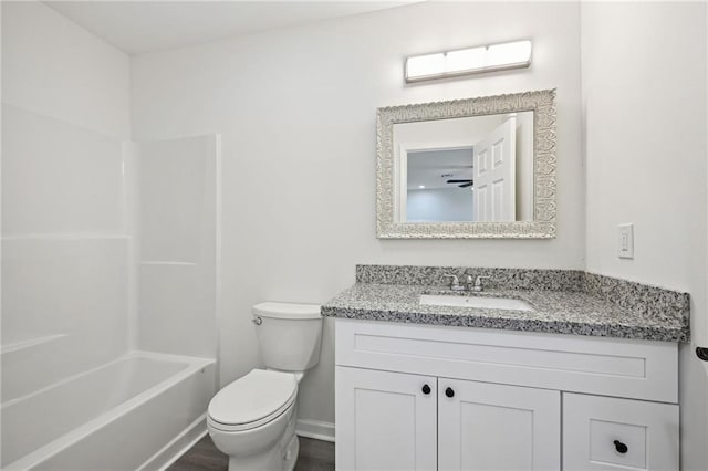 bathroom with bathtub / shower combination, toilet, baseboards, and vanity