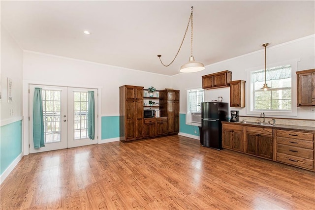 34310 Bluff Line Rd, Independence, LA 70443 - kitchen with a sink, decorative light fixtures, light wood-style floors, french doors, and freestanding refrigerator