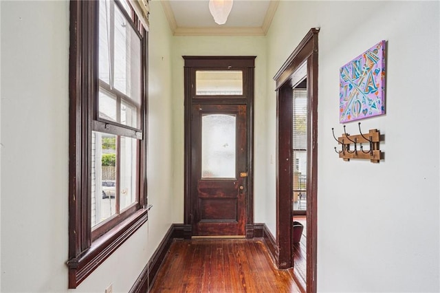 doorway featuring ornamental molding, baseboards, and dark wood finished floors