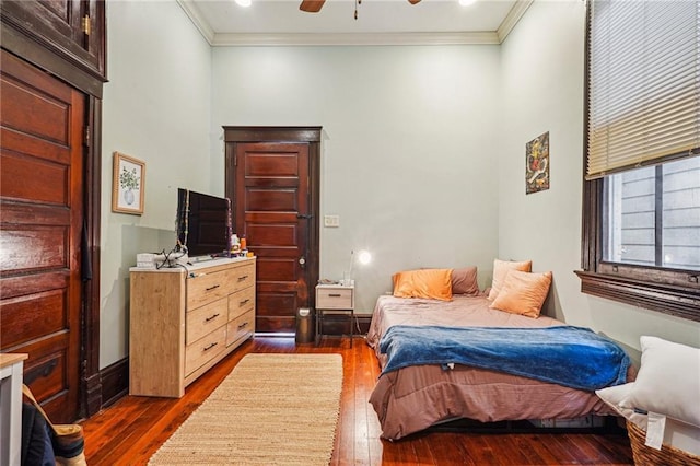 bedroom with crown molding, ceiling fan, and dark wood-style flooring