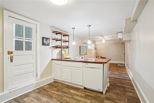kitchen featuring dark wood-style flooring, white dishwasher, a sink, and a peninsula