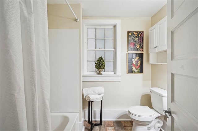 bathroom with toilet and shower / bath combo with shower curtain