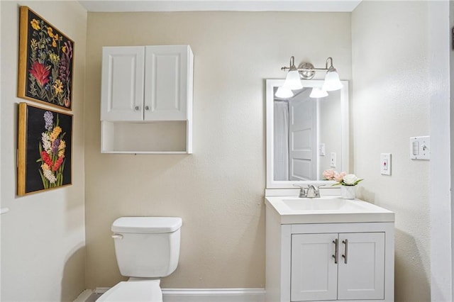 half bathroom featuring baseboards, toilet, and vanity