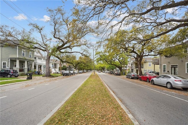 view of road with a residential view and curbs