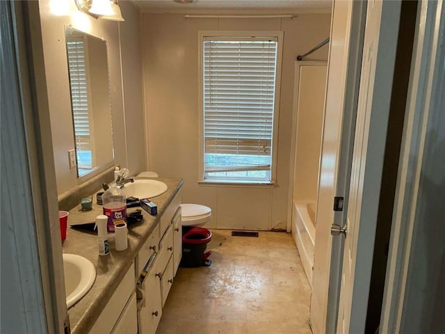 bathroom with concrete floors, double vanity, toilet, and a sink