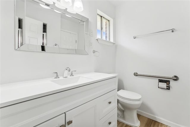 13118 Lemans St, New Orleans, LA 70129 - bathroom with vanity, toilet, wood finished floors, and baseboards