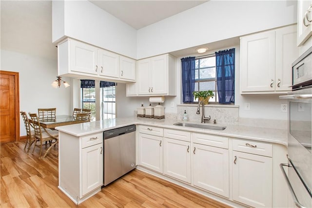 132 Country Club Dr, Covington, LA 70433 - kitchen with white cabinetry, a sink, a peninsula, and dishwasher