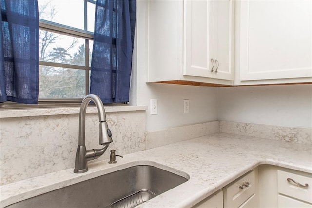 132 Country Club Dr, Covington, LA 70433 - kitchen featuring white cabinetry, a sink, and light stone counters