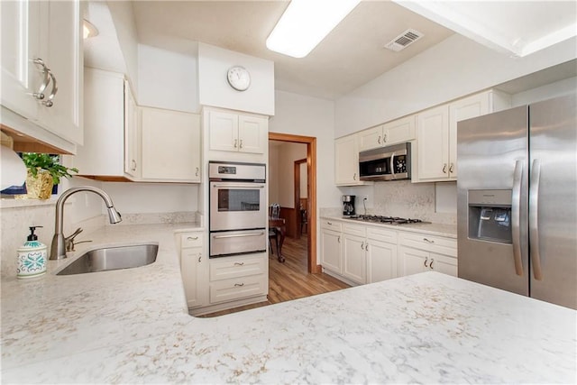 132 Country Club Dr, Covington, LA 70433 - kitchen with decorative backsplash, visible vents, stainless steel appliances, a sink, and a warming drawer