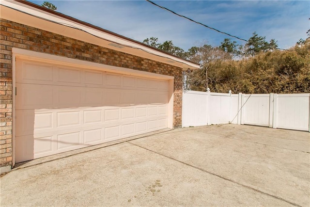 132 Country Club Dr, Covington, LA 70433 - garage featuring concrete driveway, a gate, and fence