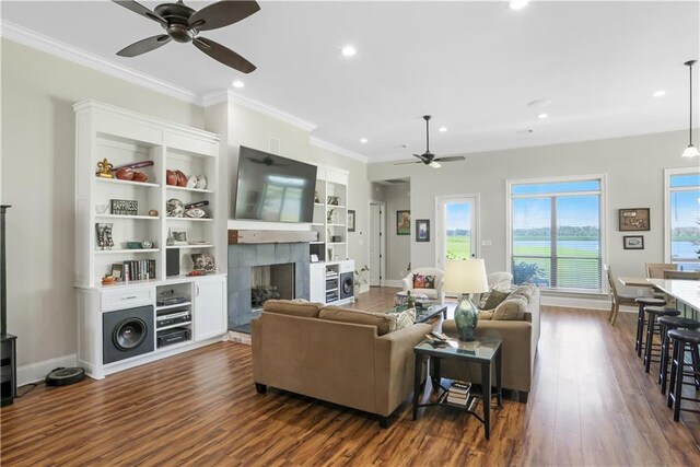 109 Moonlight Cove Ln, Luling, LA 70070 - living room featuring a ceiling fan, a fireplace, dark wood-style flooring, recessed lighting, and crown molding