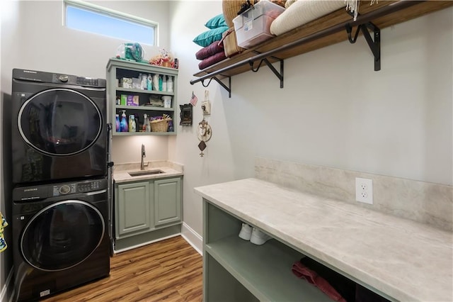 109 Moonlight Cove Ln, Luling, LA 70070 - washroom with stacked washer and clothes dryer, cabinet space, wood finished floors, and bar with sink